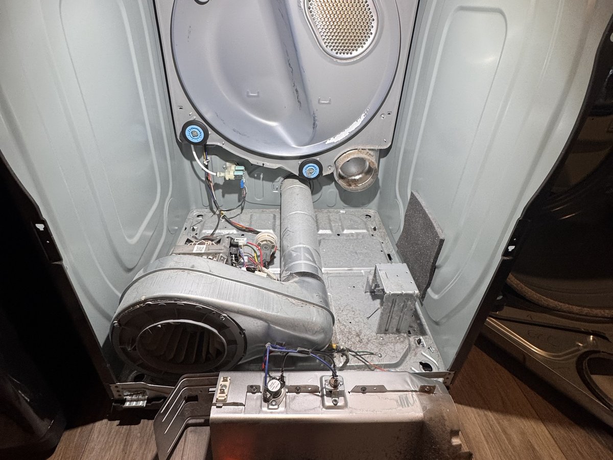 New heating element installed in the heater housing with thermostats, being tested with a clamp meter
